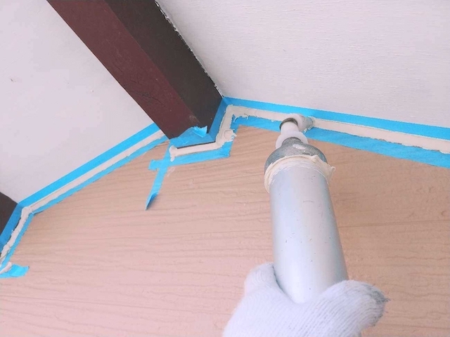 軒天・外壁の間をコーキングする風景